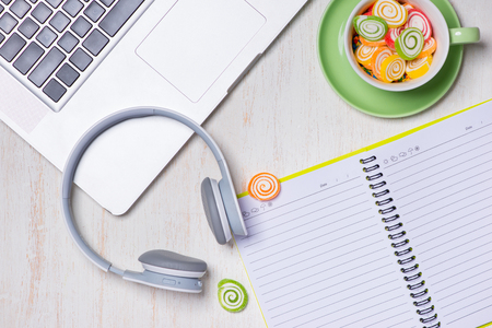 Candies, headphones and notepad on wooden table. Open space for copy.の写真素材