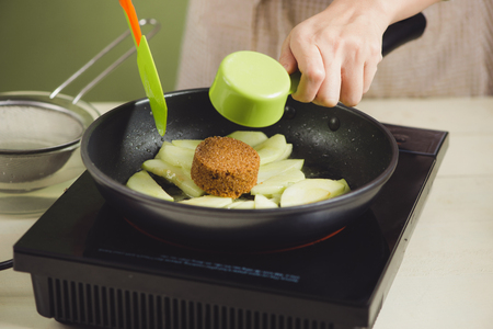 House wife wearing apron making. Steps of making cooking apple cake. Cutting green apple.の写真素材
