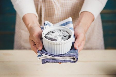 Chocolate homemade dark muffin in mom hands.の写真素材