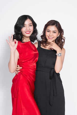 Two fashionable women in nice dresses standing together and having funの写真素材
