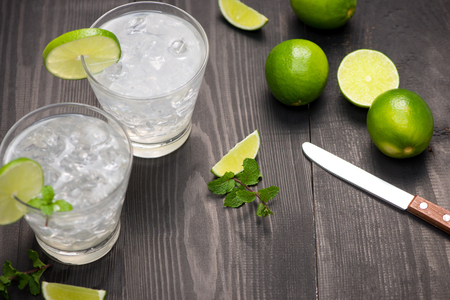 Fresh cocktail with lime, ice and mint on a rustic background. Copy space, top viewの写真素材