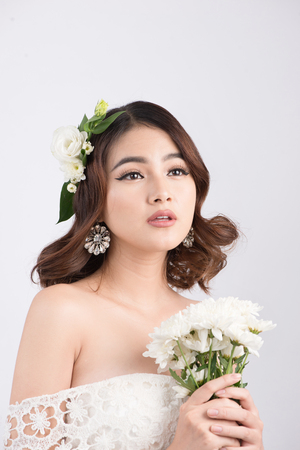 Beautiful asian woman bride on grey background. Closeup portraits with a professional makeupの写真素材