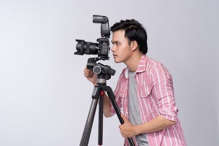 Young asian photographer holding digital camera, while working in studioの写真素材