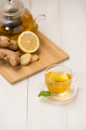 Cup of ginger tea with lemon and honey on white wooden background.の写真素材