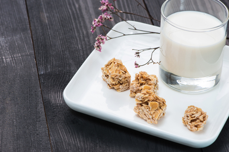 Milk with almond candies on a wooden tableの写真素材