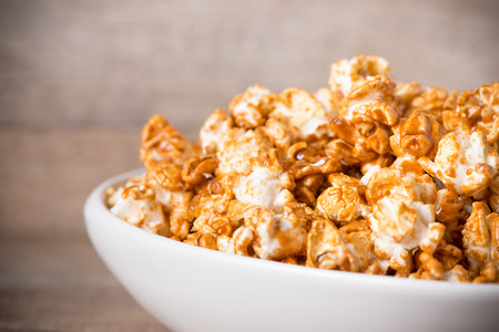 Caramel opcorn in bowl on the wooden table.の写真素材