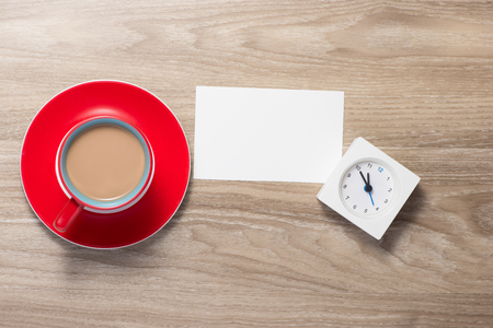 Open notebook with clock and cup of coffee on the deskの写真素材