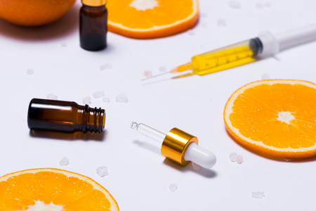 Branding mock-up. Natural essential oil, Cosmetic bottle containers with orange slices.の写真素材