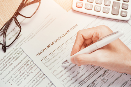 Hand writes the personal information on the health insurance claim formの写真素材