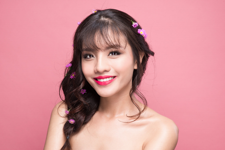 Beauty portrait of young asian woman with perfect make-up. Beautiful model girl with fresh clear skin on pink background.の写真素材