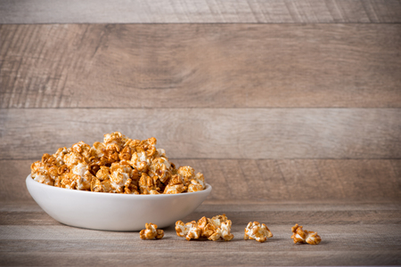 Caramel opcorn in bowl on the wooden table.の写真素材
