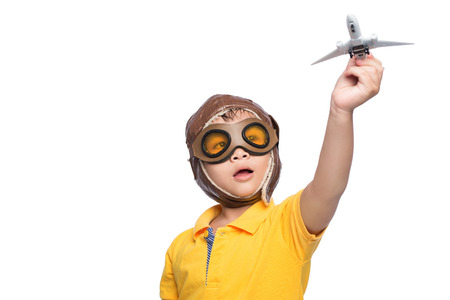 Beautiful smiling child boy in helmet on a white background playing with a plane.の写真素材