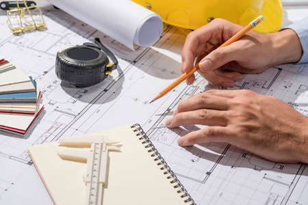 Working on blueprints. Construction project with tools and notebook.の写真素材