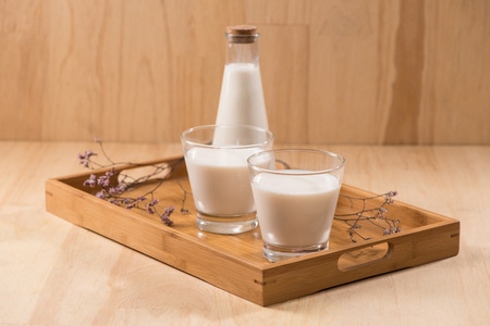 Dairy products. A bottle of milk and glass of milk on a wooden table.の写真素材