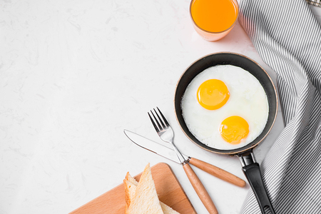 Top view of traditional healthy easy quick breakfast meal made of fried eggs served on a frying pan.の写真素材