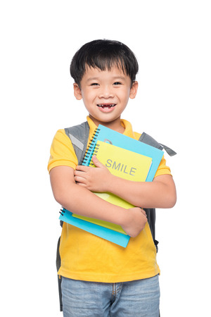 Portrait of cute smiling boy with backpack and colorful books, education and back to school conceptの写真素材