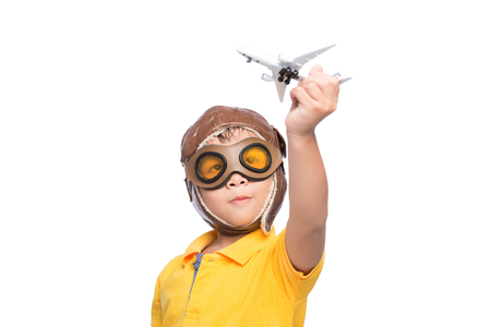 Beautiful smiling child boy in helmet on a white background playing with a plane.の写真素材