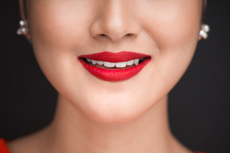 Beauty. Close up view of beautiful woman lips with red matt lipstickの写真素材