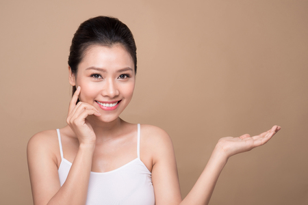 Proposing a product. Beautiful spa woman showing empty copy space on the open hand palmの写真素材