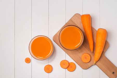Fresh carrot juice in glass on wooden table.の写真素材