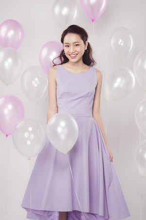 Asian pretty fashionable woman with pastel balloonsの写真素材