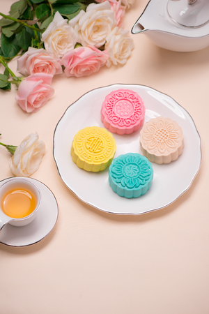 Sweet color of snow skin mooncake. Traditional mid autumn festival foods with tea on table setting.の写真素材