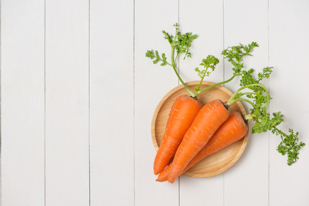 Fresh organic carrots on white wooden backgroundの写真素材