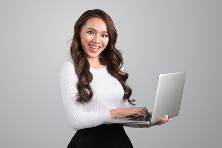 Confident young asian woman holding laptopの写真素材