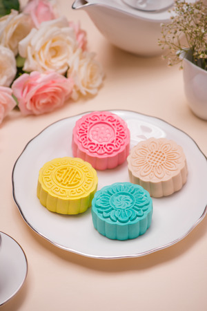Sweet color of snow skin mooncake. Traditional mid autumn festival foods with tea on table setting.の写真素材