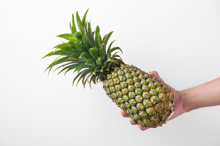 Male hand holding a pineapple isolated on white.の写真素材