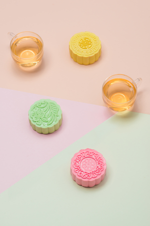 Sweet color of snow skin mooncake. Traditional mid autumn festival foods with tea on table setting.の写真素材