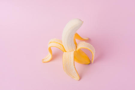 Fresh peeled banana on pink backgroundの写真素材