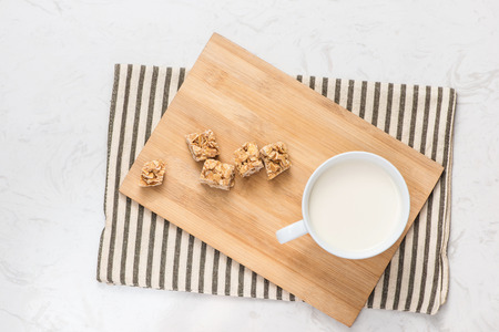 Dairy products. A cup of milk serve with almond candies on a rustic wooden table.の写真素材