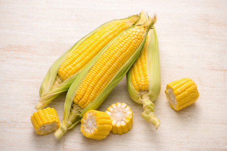 Sweet corns. Fresh corn on cobs on wooden table.の写真素材