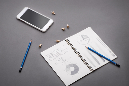 Creative sketch in spiral notepad with laptop on desk. Business starup plan.の写真素材