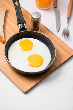 Traditional breakfast with fried eggs on a plateの写真素材