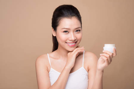 Skincare. Beautiful asian woman show moisturizer or lotion product.の写真素材