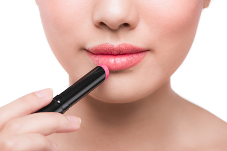 Beautiful young asian woman applying pink lipstickの写真素材
