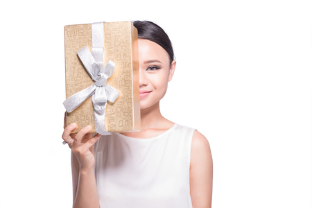 Beautiful Asian woman holding gold gift box on white backgroundの写真素材