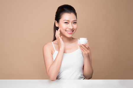 Skincare. Beautiful asian woman show moisturizer or lotion product.の写真素材