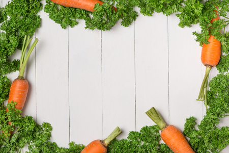Fresh raw carrots with vegetables on wooden table.の写真素材