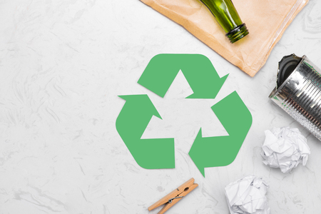 Eco concept. Waste recycling symbol with garbage on stoneの写真素材