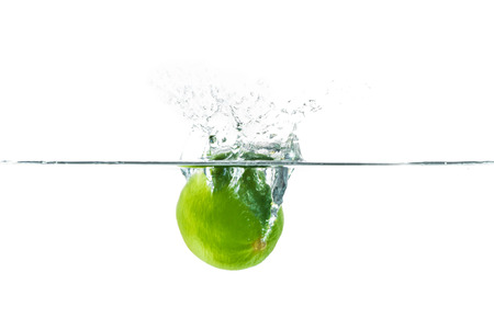 Fresh lime dropped into the water with water splash on a white backgroundの写真素材
