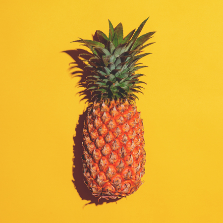 Summer fruit. Pineapple on bright yellow background.の写真素材