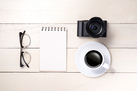 White set. Camera, pen, eyeglasses, coffee and notebook on table. Top view.の写真素材