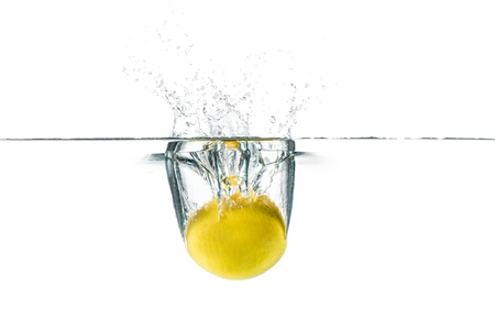 Fresh lemon dropped into the water with water splash on a white backgroundの写真素材
