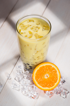 Bubble tea. Homemade Orange Milk Tea with Pearls on wooden table.の写真素材