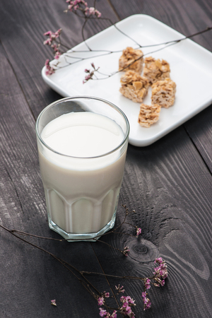 Dairy products. A glass of milk serve with almond candies on a rustic wooden table.の写真素材