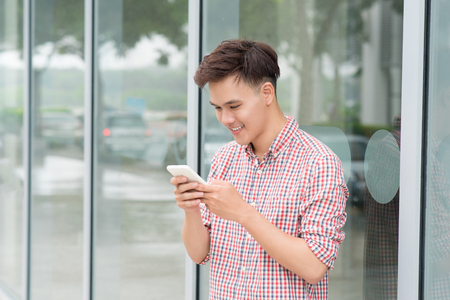 Young man using mobile phone at outdoorの写真素材