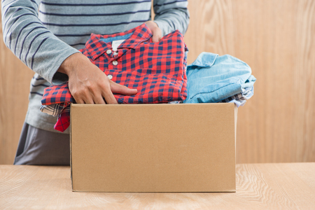 Donation box for poor with clothing in male handsの写真素材